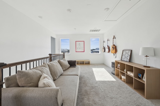 living room with attic access, carpet flooring, and visible vents