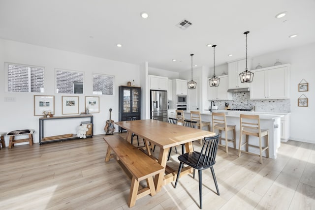 dining room with recessed lighting, visible vents, light wood-style flooring, and baseboards