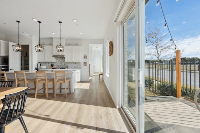 interior space featuring recessed lighting, a water view, and light wood finished floors