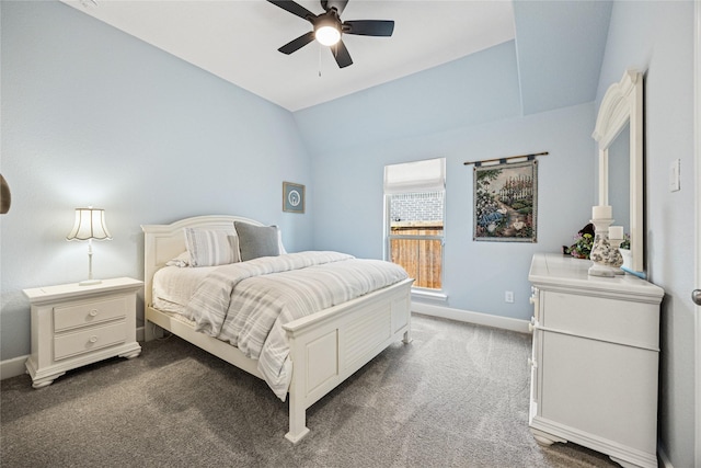 bedroom with vaulted ceiling, dark colored carpet, ceiling fan, and baseboards