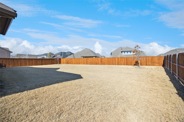 view of yard featuring a fenced backyard and a residential view