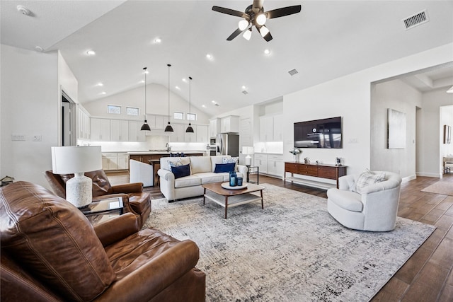 living area with visible vents, baseboards, ceiling fan, wood finished floors, and high vaulted ceiling