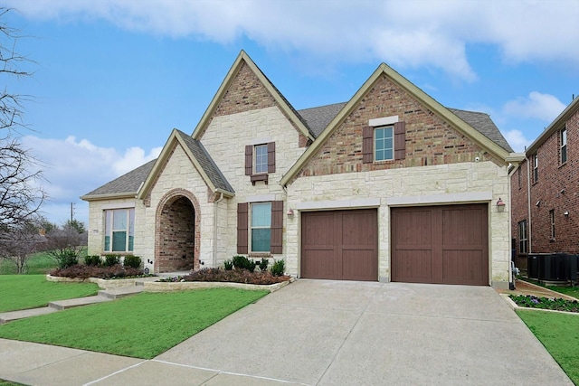 view of front of property featuring driveway, brick siding, a front yard, and a shingled roof