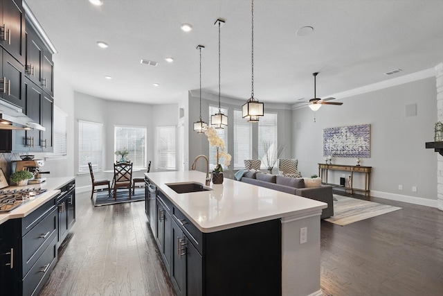 kitchen with stainless steel gas stovetop, light countertops, a sink, and visible vents