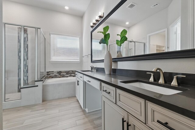 full bath with a garden tub, a stall shower, a sink, and visible vents