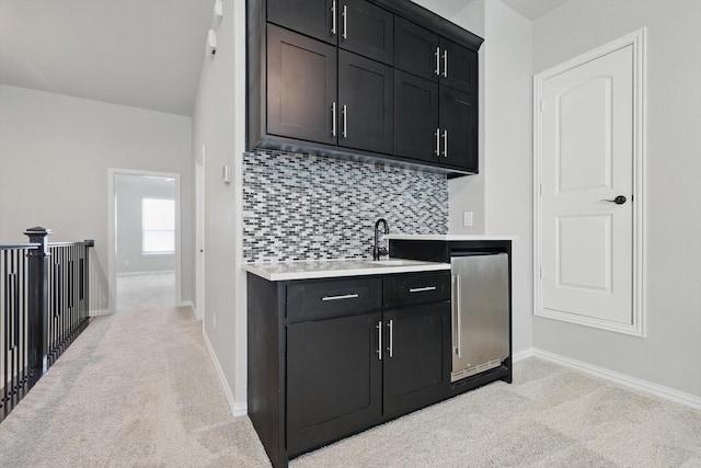 bar with a sink, baseboards, decorative backsplash, and light colored carpet