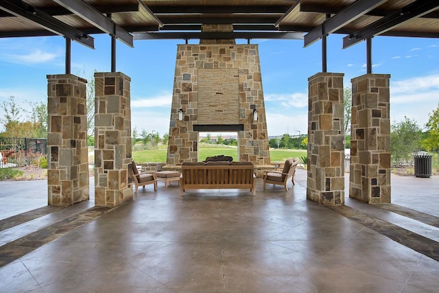 view of patio with an outdoor living space with a fireplace