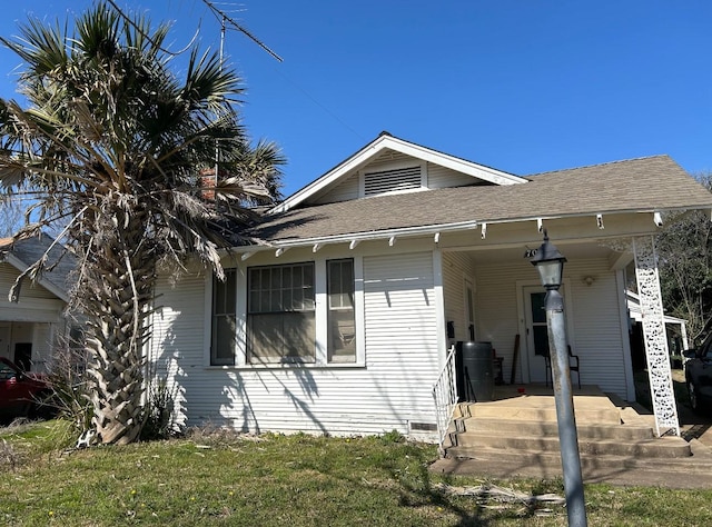 view of front of property featuring a front yard and roof with shingles