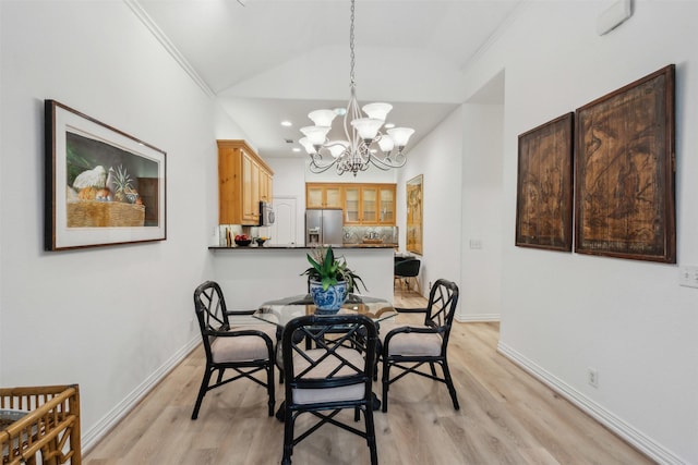 dining space featuring vaulted ceiling, baseboards, a notable chandelier, and light wood-style floors