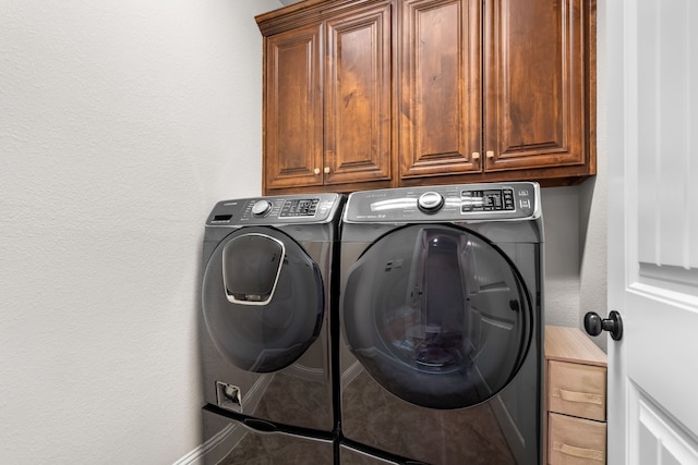 laundry room with cabinet space and washing machine and clothes dryer