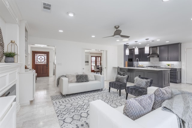 living area with a ceiling fan, visible vents, and recessed lighting