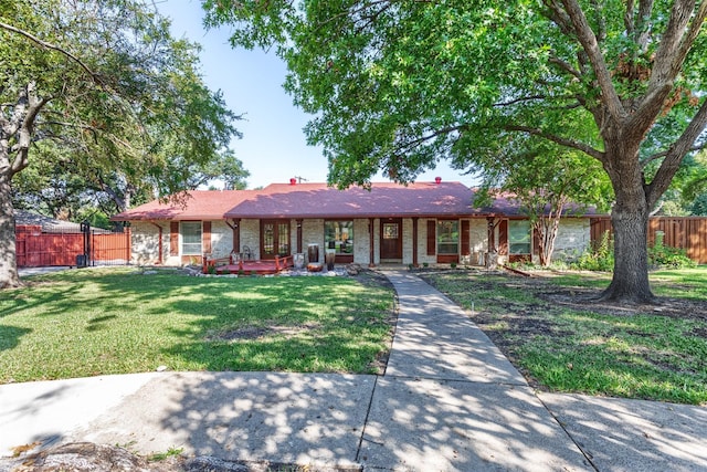 single story home featuring a front yard, brick siding, and fence