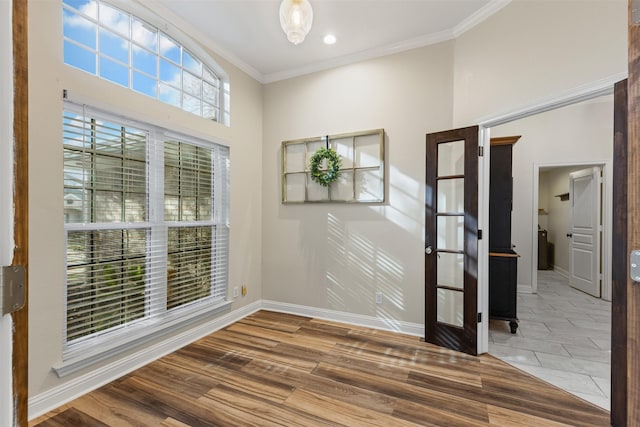 spare room with wood finished floors, baseboards, and ornamental molding