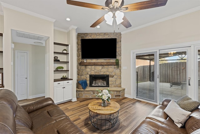 living area with a fireplace, wood finished floors, and ornamental molding