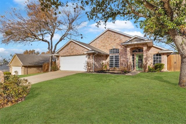 traditional home with brick siding, an attached garage, fence, driveway, and a front lawn