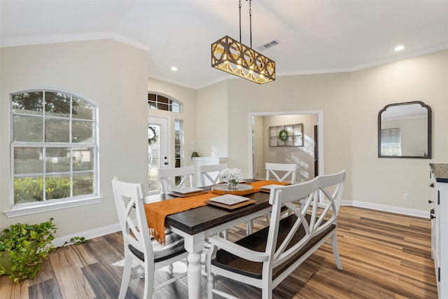 dining space featuring crown molding, wood finished floors, visible vents, and baseboards