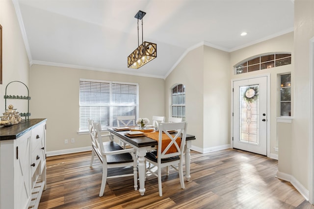 dining room featuring wood finished floors, baseboards, and ornamental molding