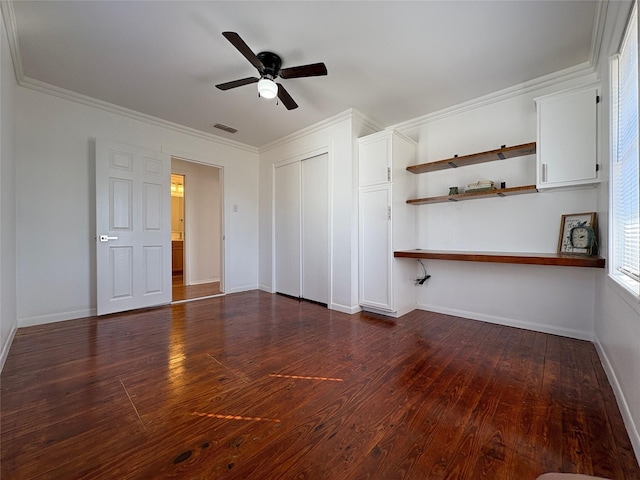 interior space featuring dark wood-style flooring, visible vents, crown molding, and baseboards