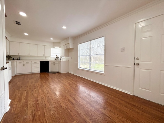 kitchen with dark wood-type flooring, white cabinetry, light countertops, dishwasher, and crown molding