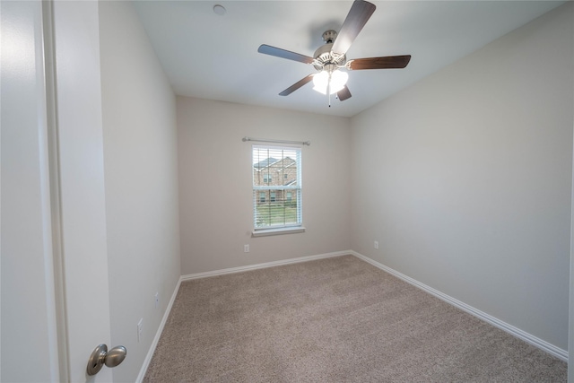 spare room featuring light carpet, ceiling fan, and baseboards