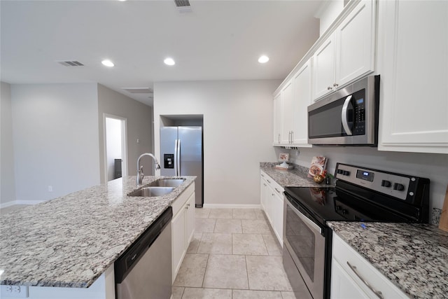 kitchen featuring a center island with sink, visible vents, white cabinets, appliances with stainless steel finishes, and a sink