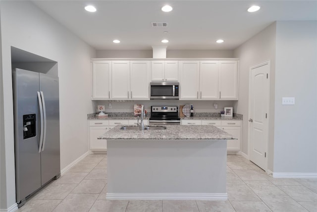 kitchen featuring a kitchen island with sink, visible vents, white cabinets, appliances with stainless steel finishes, and light stone countertops