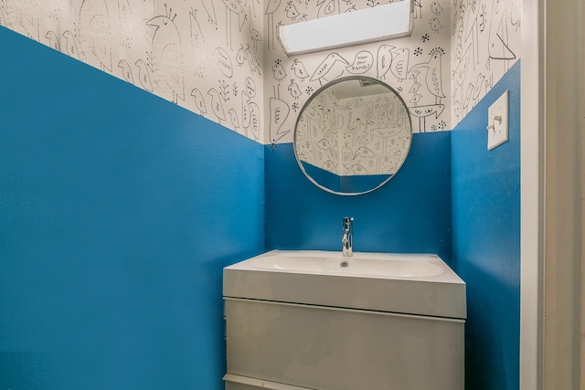 bathroom featuring a sink and wallpapered walls