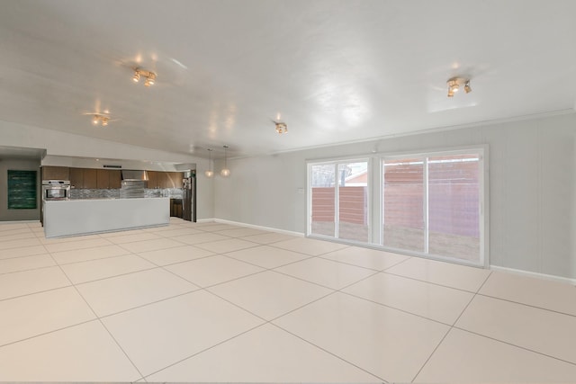 unfurnished living room with baseboards and light tile patterned floors