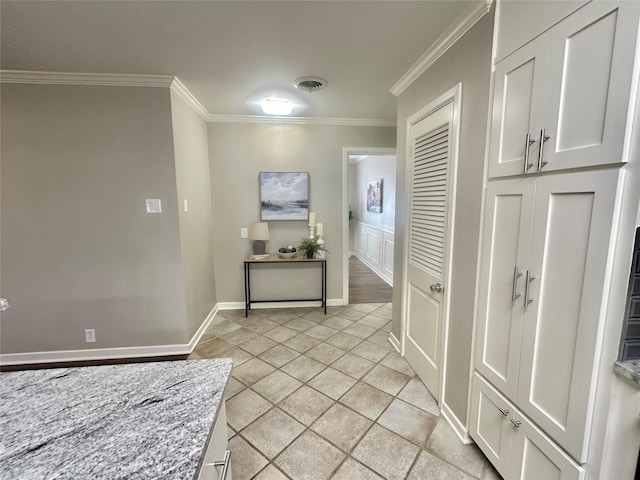 hallway featuring baseboards, visible vents, and crown molding