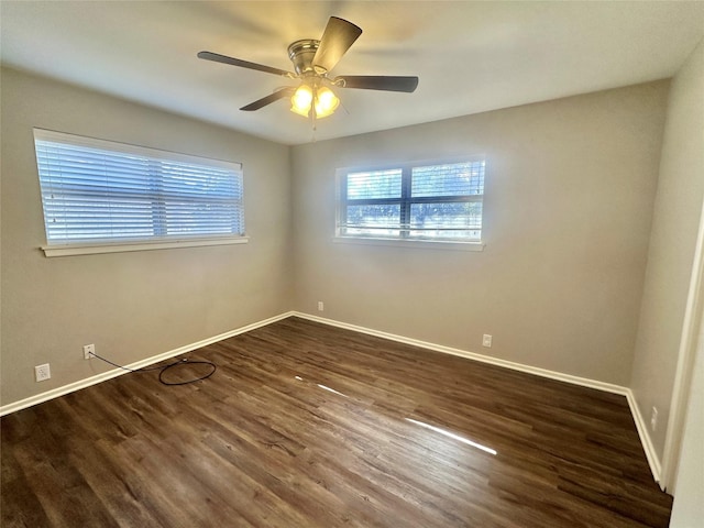 empty room with a ceiling fan, dark wood-style flooring, and baseboards