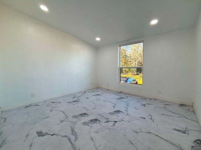 spare room featuring marble finish floor, recessed lighting, and baseboards