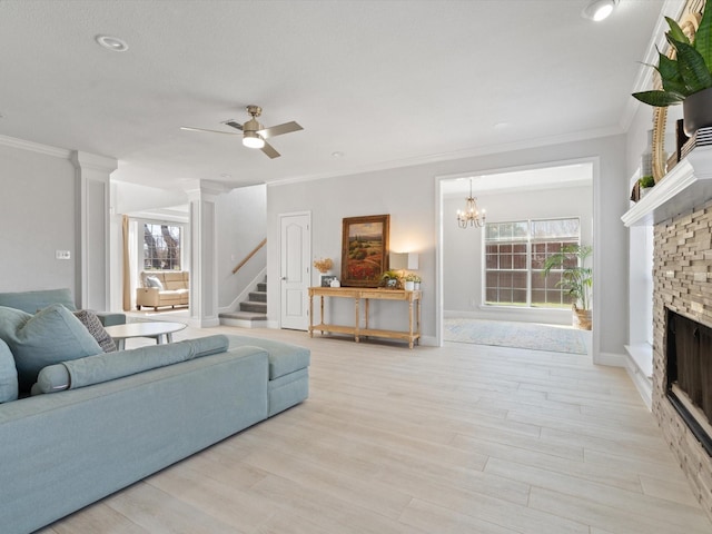 living room featuring stairway, a fireplace, light wood-style floors, and ornamental molding