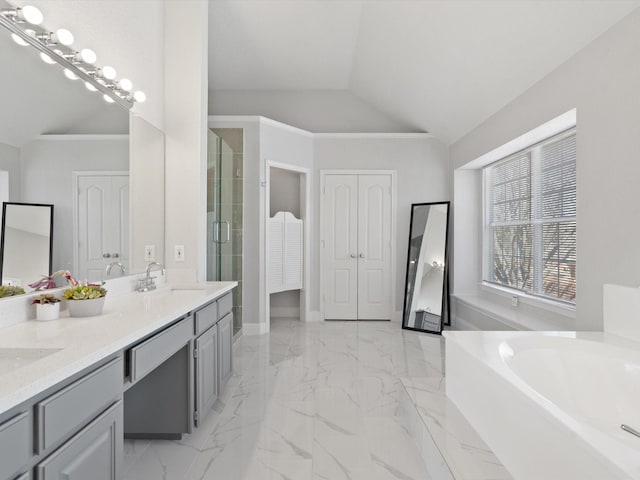 full bath with a sink, marble finish floor, a stall shower, and vaulted ceiling