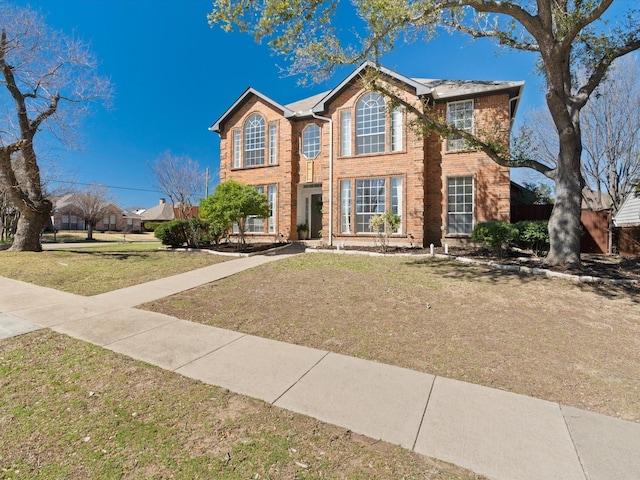 view of front of home featuring brick siding and a front lawn