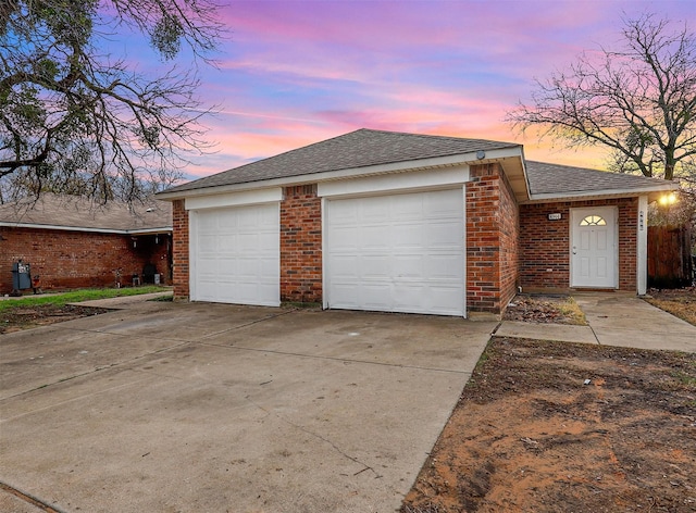 4966 Willie St, Fort Worth, TX 76105 - view of front of house with a garage, brick siding, driveway, and roof with shingles