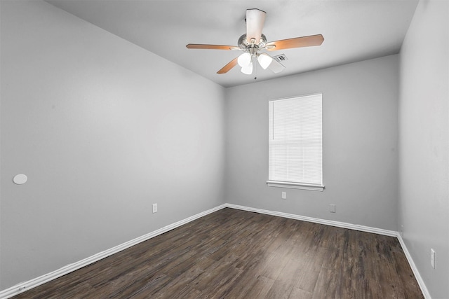 unfurnished room with a ceiling fan, visible vents, dark wood finished floors, and baseboards