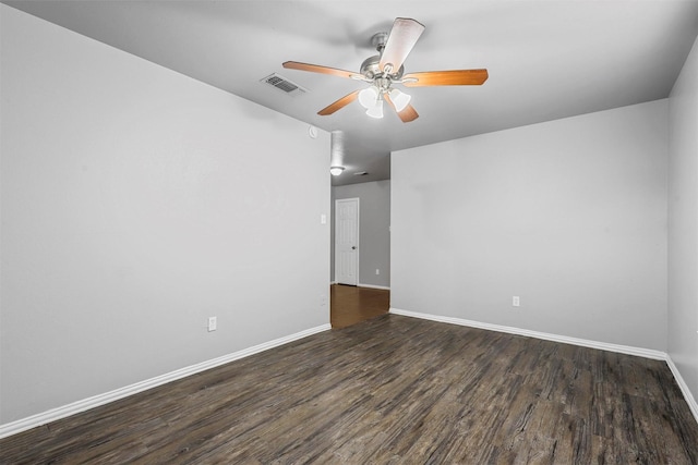 spare room featuring dark wood-type flooring, visible vents, ceiling fan, and baseboards