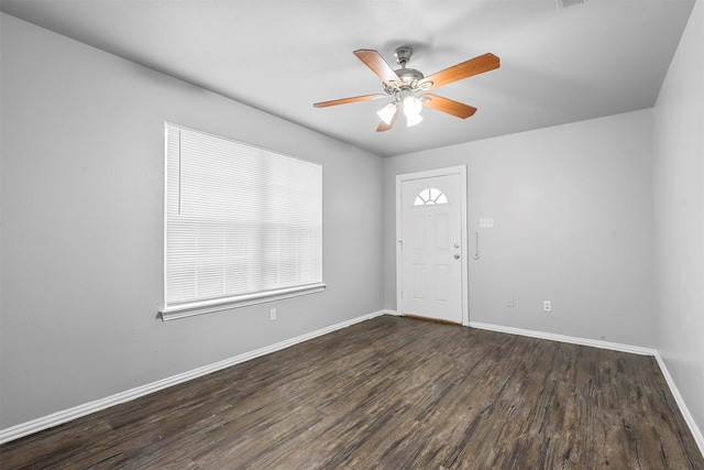 empty room featuring dark wood finished floors, baseboards, and ceiling fan