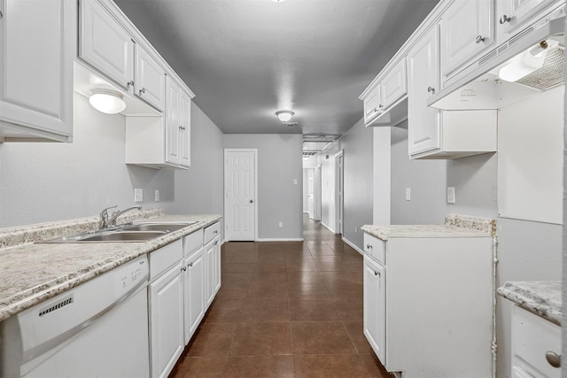 kitchen with white cabinetry, a sink, dark tile patterned flooring, dishwasher, and under cabinet range hood