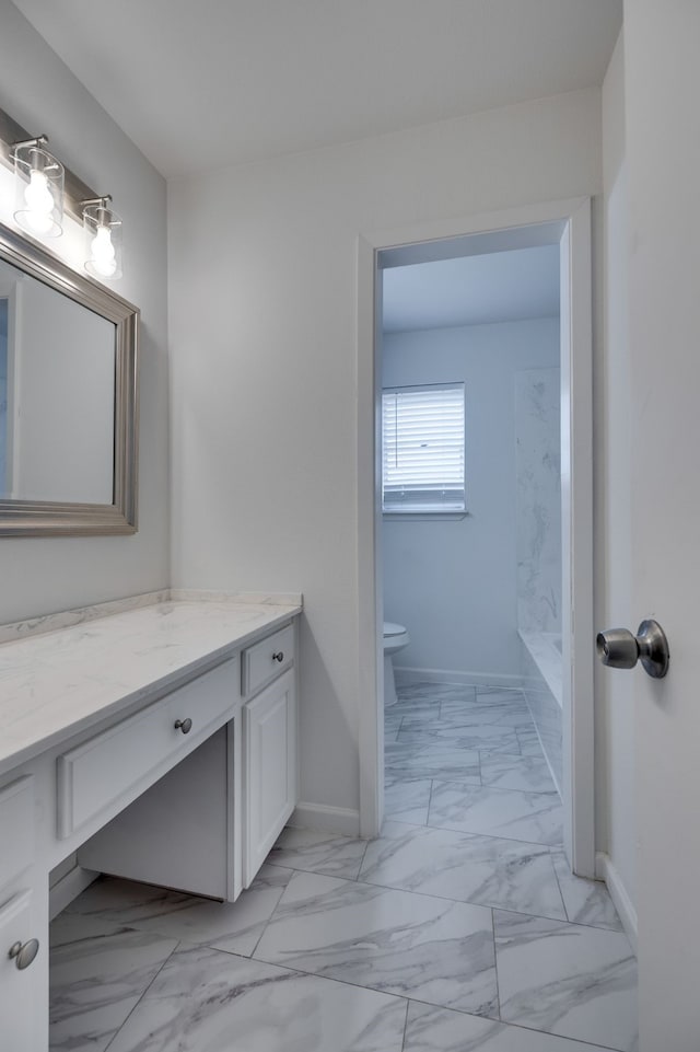 full bath featuring vanity, toilet, baseboards, and marble finish floor