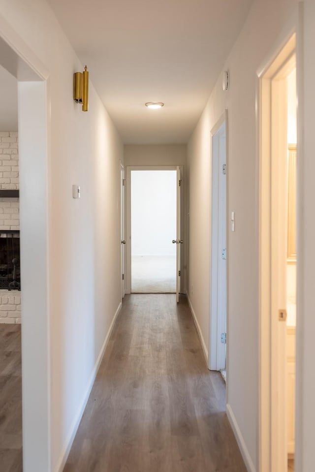 corridor with wood finished floors and baseboards