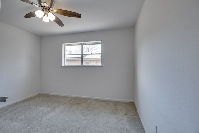 unfurnished room with carpet flooring, baseboards, and a ceiling fan
