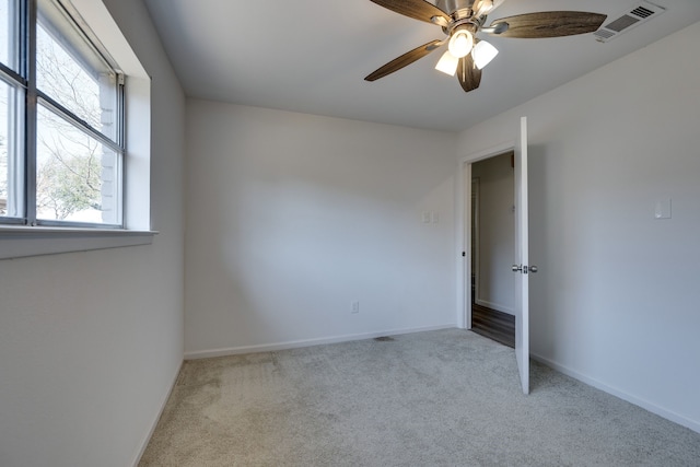 unfurnished bedroom featuring carpet flooring, visible vents, baseboards, and a ceiling fan
