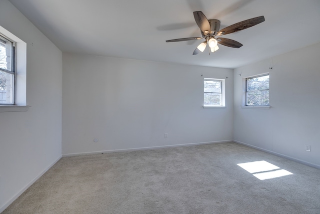 carpeted spare room with baseboards and a ceiling fan