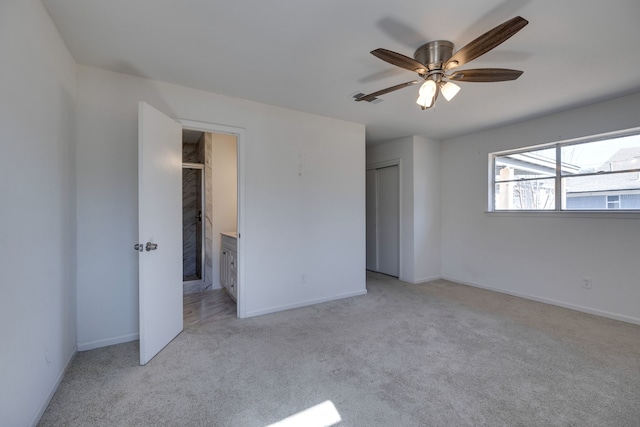 unfurnished bedroom featuring a closet, ensuite bathroom, baseboards, and carpet floors