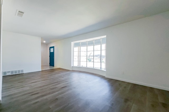 unfurnished living room featuring wood finished floors, visible vents, and baseboards