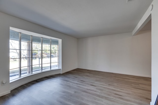unfurnished room featuring baseboards and wood finished floors