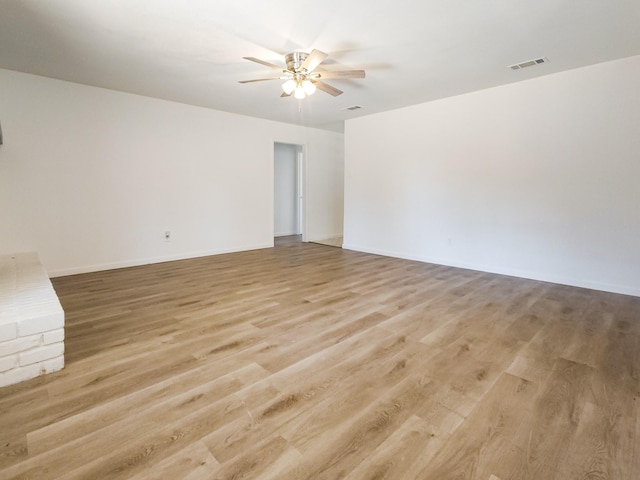 unfurnished living room with a ceiling fan, baseboards, visible vents, and light wood-type flooring