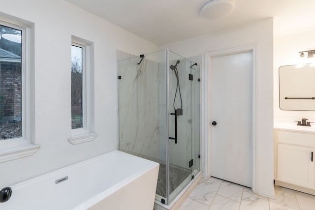 full bathroom with marble finish floor, a freestanding tub, vanity, and a marble finish shower