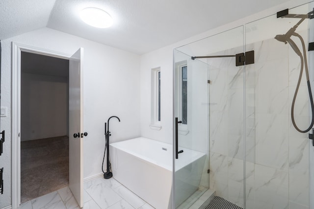 full bath with a textured ceiling, lofted ceiling, a freestanding tub, marble finish floor, and a marble finish shower